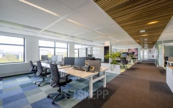 Moderne en lichte kantoorruimte huren in een kantoorpand aan Boeingavenue 223 – 239, Schiphol Rijk. Ruime werkplekken met bureaus, stoelen en computers, geschikt voor zakelijke activiteiten.