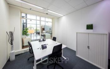 Moderne kantoorruimte met heldere verlichting, voorzien van een bureau en stoelen bij Beechavenue, Schiphol.