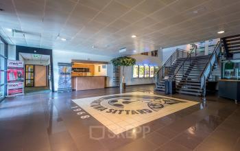 Ruime entree van het kantoorpand op 200 Milaanstraat, Sittard met een moderne receptie en opvallende vloerbedekking met design. Ideaal voor wie kantoorruimte wil huren in een professionele omgeving.