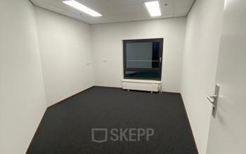 Lege kantoorruimte aan de Milaanstraat 200 in Sittard, met witte muren en een raam, ideaal voor het huren als werkplek.