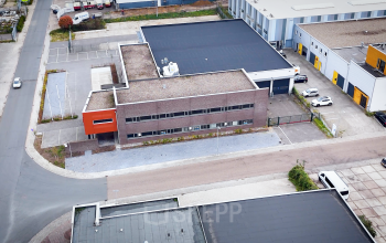 Luchtfoto van kantoorpand op Fischerpad 106 in Sittard met omliggende parkeerplaatsen.