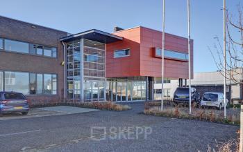 Exterieur van een kantoorpand aan het Fischerpad 106 in Sittard, met parkeerplaatsen en moderne architectuur. Kantoorruimte huren mogelijk in dit opvallende gebouw.
