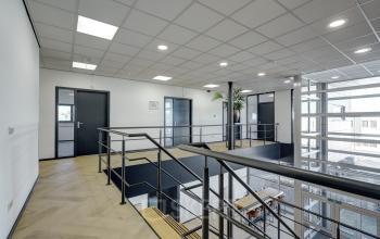 Moderne kantoorruimte met zicht op trap en glazen wanden, ideaal voor wie kantoorruimte wil huren in Sittard.