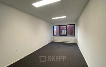 Leeg kantoorpand op Nusterweg 63, met tapijt en een groot raam voor natuurlijk licht, geschikt voor kantoorruimte huren in Sittard.