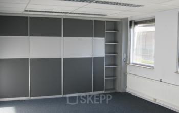Leeg kantoor op Nusterweg 63 in Sittard met grote ramen en een grijze wandkast. Ideaal voor kantoorruimte huren.