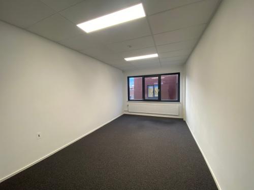 Leeg kantoorpand op Nusterweg 63, met tapijt en een groot raam voor natuurlijk licht, geschikt voor kantoorruimte huren in Sittard.