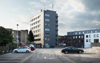 Exterieur van het kantoorpand op Stationsplein 1 in Sittard, beschikbaar voor kantoorruimte huren, met parkeerplaatsen aan de voorzijde.