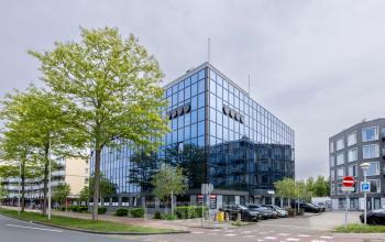 Modern kantoorpand aan de Curieweg 9 in Spijkenisse met een strakke glazen gevel en parkeermogelijkheden, ideaal voor wie kantoorruimte wil huren.
