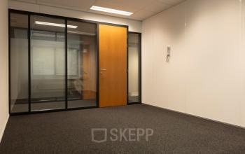 Lichte kantoorruimte in Spijkenisse met glazen wand en houten deur, ideaal voor wie kantoorruimte wil huren op Curieweg 9.