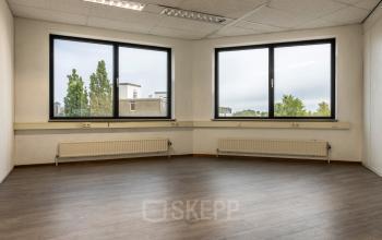 Kantoorruimte te huur op Curieweg 9 in Spijkenisse met grote ramen en laminaatvloer, ideaal voor inrichten naar wens.
