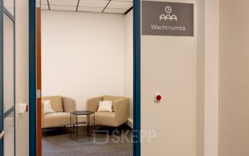 Kantoorruimte huren in Spijkenisse aan de Curieweg 9 met een uitnodigende wachtruimte voorzien van comfortabele stoelen en een bijzettafel.