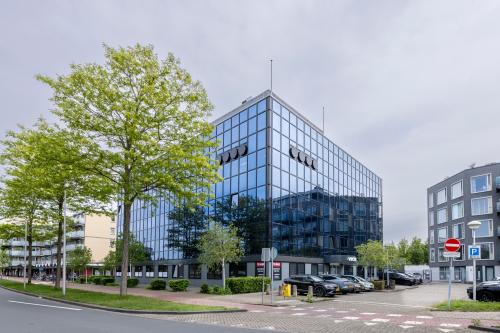 Modern kantoorpand aan de Curieweg 9 in Spijkenisse met een strakke glazen gevel en parkeermogelijkheden, ideaal voor wie kantoorruimte wil huren.