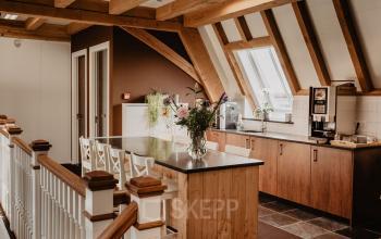 Moderne kantoorruimte huren in Breda Terheijden met houten afwerking en goed verlichte keukenhoek met koffiezetapparaat.