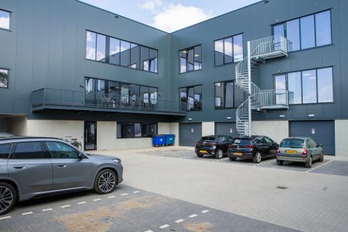 Buitenaanzicht van een modern kantoorpand op Kapitein Rondairestraat 8 in Tilburg met meerdere parkeerplaatsen voor de deur.