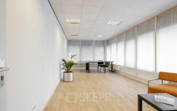 Modern ingerichte kantoorruimte met een strakke zwarte tafel en comfortabele stoelen in kantoorpand aan Jules de Beerstraat 14, Tilburg.