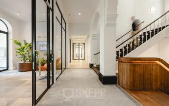 Lichte en ruime kantoorruimte in het kantoorpand op Moreelsepark 1, Utrecht Centraal Station met moderne inrichting en een persoon die de trap op loopt.