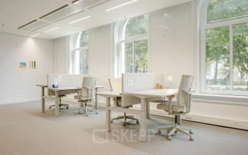 Lichte kantoorruimte met vier bureaus, stoelen en grote ramen op Moreelsepark 1, ideaal om kantoorruimte te huren in Utrecht Centraal Station.