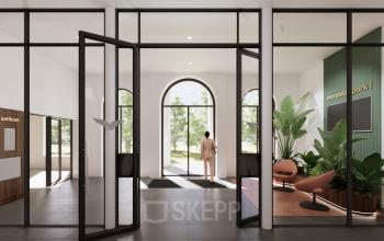 Moderne kantoorentree in kantoorpand Moreelsepark 1, Utrecht. Glazen deuren en grote ramen met uitzicht op groen. Een persoon in zakelijke kleding loopt naar buiten. Ideaal voor kantoorruimte huren.