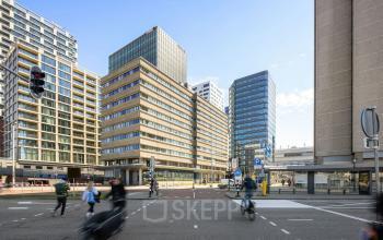 Kantoorpand op Jaarbeursplein 22, Utrecht Centraal Station, met moderne architectuur en druk verkeer op de voorgrond. Ideaal voor kantoorruimte huren.
