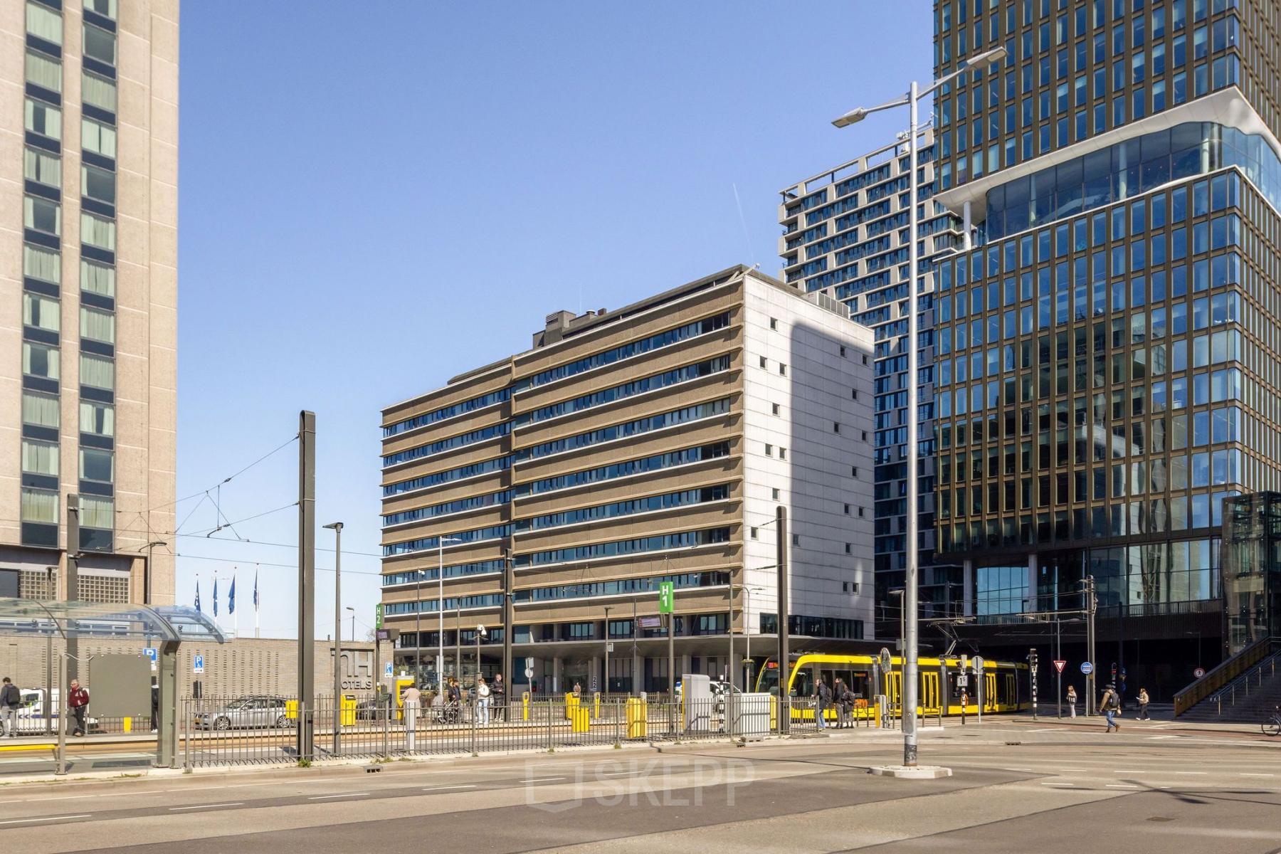 Kantoorgebouwen op Jaarbeursplein 22 bij Utrecht Centraal Station, met moderne architectuur en tramhalte op de voorgrond. Ideaal voor kantoorruimte huren in het centrum van Utrecht.