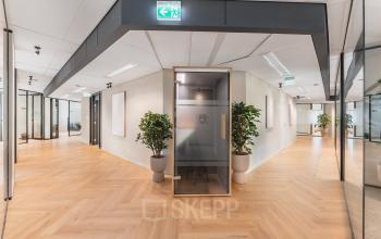 Moderne kantoorruimte met glazen wanden en houten vloer op Leidseveer 2-10, Utrecht Centraal Station, ideaal voor werkruimten huren.