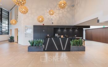 Moderne entree van een kantoorpand bij Utrecht Centraal Station, met stijlvolle verlichting en plantenbakken. Ideaal voor kantoorruimte huren op Leidseveer 2-10.