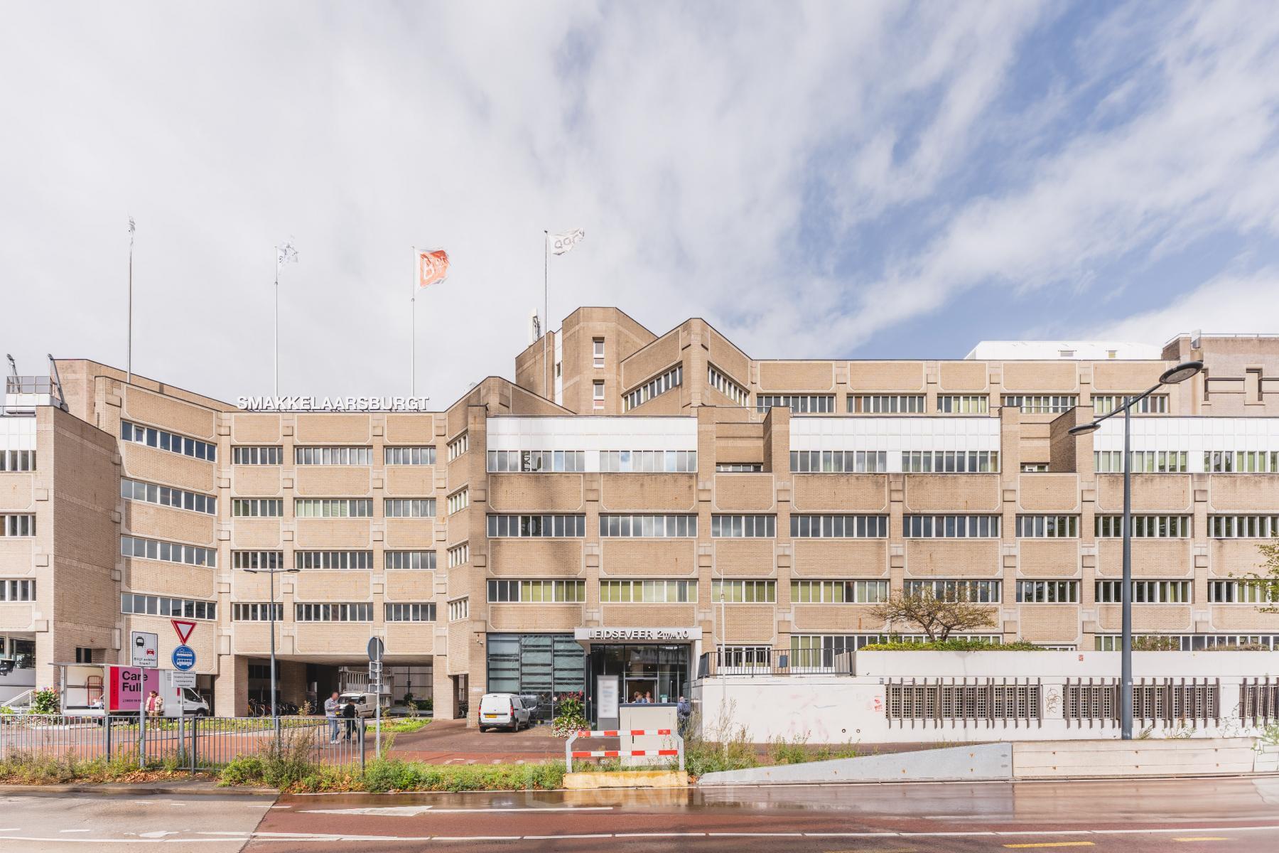 Kantoorpand aan Leidseveer 2-10 bij Utrecht Centraal Station met meerdere ingangen en parkeerplaatsen aan de voorkant van het gebouw.