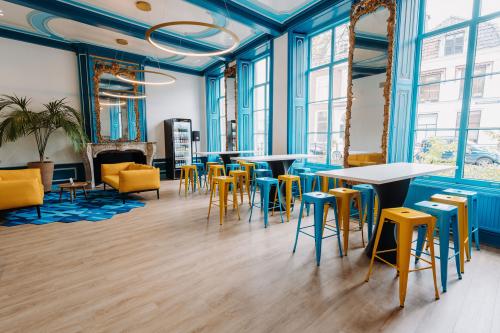 Kantoorpand huren in Utrecht Centrum op Kromme Nieuwegracht 3, modern ingericht met felgekleurde stoelen en tafels, grote ramen en spiegels aan de muren.