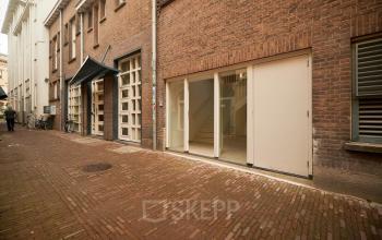 Exterieur van kantoorpand aan de Oudegracht 161 in Utrecht Centrum met bakstenen gevel en grote ramen.