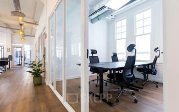 Moderne kantoorruimte huren op Oudegracht 161 in Utrecht Centrum met ruime vergadertafel, ergonomische stoelen en veel natuurlijk licht door grote ramen.