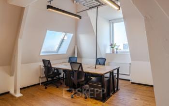 Lichte kantoorruimte huren op Nicolaas Beetsstraat 216 in Utrecht Centrum, Utrecht met houten vloer en vier bureaus met stoelen onder een schuin dakraam, ingericht voor werk.