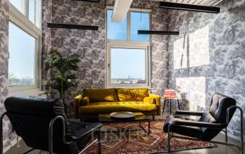 Kantoorruimte huren aan de Nicolaas Beetsstraat 216 in Utrecht Centrum met moderne inrichting, waaronder comfortabele stoelen, gele bank en grote ramen met uitzicht.