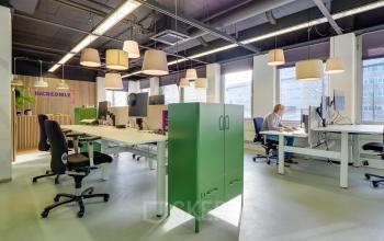 Moderne kantoorruimte aan Europalaan 500 in Utrecht Kanaleneiland, met flexibele werkplekken en stijlvolle verlichting, ideaal voor bedrijven die een inspirerende omgeving huren. Mensen zijn bezig met zakelijke activiteiten aan bureaus.