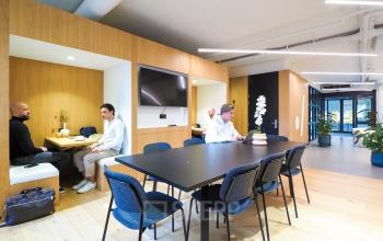 Kantoorpand op Europalaan 500 in Utrecht, Kanaleneiland met modern gemeubileerde vergaderruimte. Personen zijn bezig met zakelijke besprekingen aan een tafel. Mogelijkheid tot kantoorruimte huren in een dynamische omgeving.