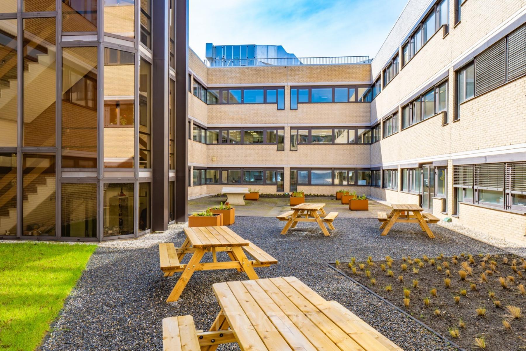 Binnenplaats van het kantoorpand op Europalaan 93, Utrecht Kanaleneiland met picknicktafels en moderne architectuur. Virtual tour voor kantoren huren.