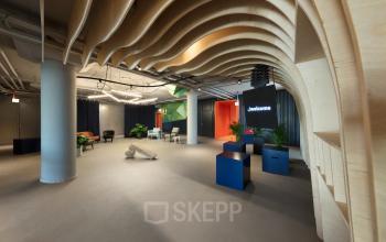 Kantoorruimte huren op Europalaan 100 in Utrecht Kanaleneiland. Moderne inrichting met stijlvolle meubels, groene planten en een opvallend houten plafond. Ideaal voor inspirerend werken of vergaderingen.