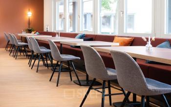 Moderne kantoorruimte huren in Utrecht Lage Weide met lange tafels en comfortabele stoelen, perfect voor samenwerken en vergaderen.