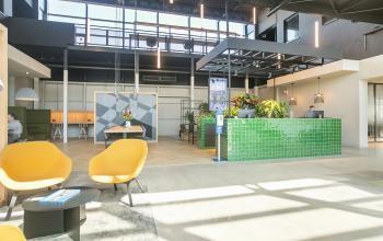 Moderne kantoorruimte met groene receptiebalie en lichte inrichting op Atoomweg 63 in Utrecht Lage Weide, ideaal voor wie kantoorruimte wil huren.