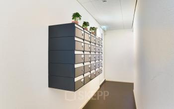 Gang in kantoorpand met lockers en planten aan de muur van Middenburcht 136, Utrecht Leidsche Rijn. Ideaal voor het huren van kantoorruimte.