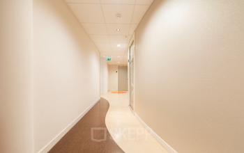 Kantoorpand Middenburcht 136, Utrecht Leidsche Rijn: lange, lichte gang met moderne afwerking en draaiende deur naar kantoorruimte huren.