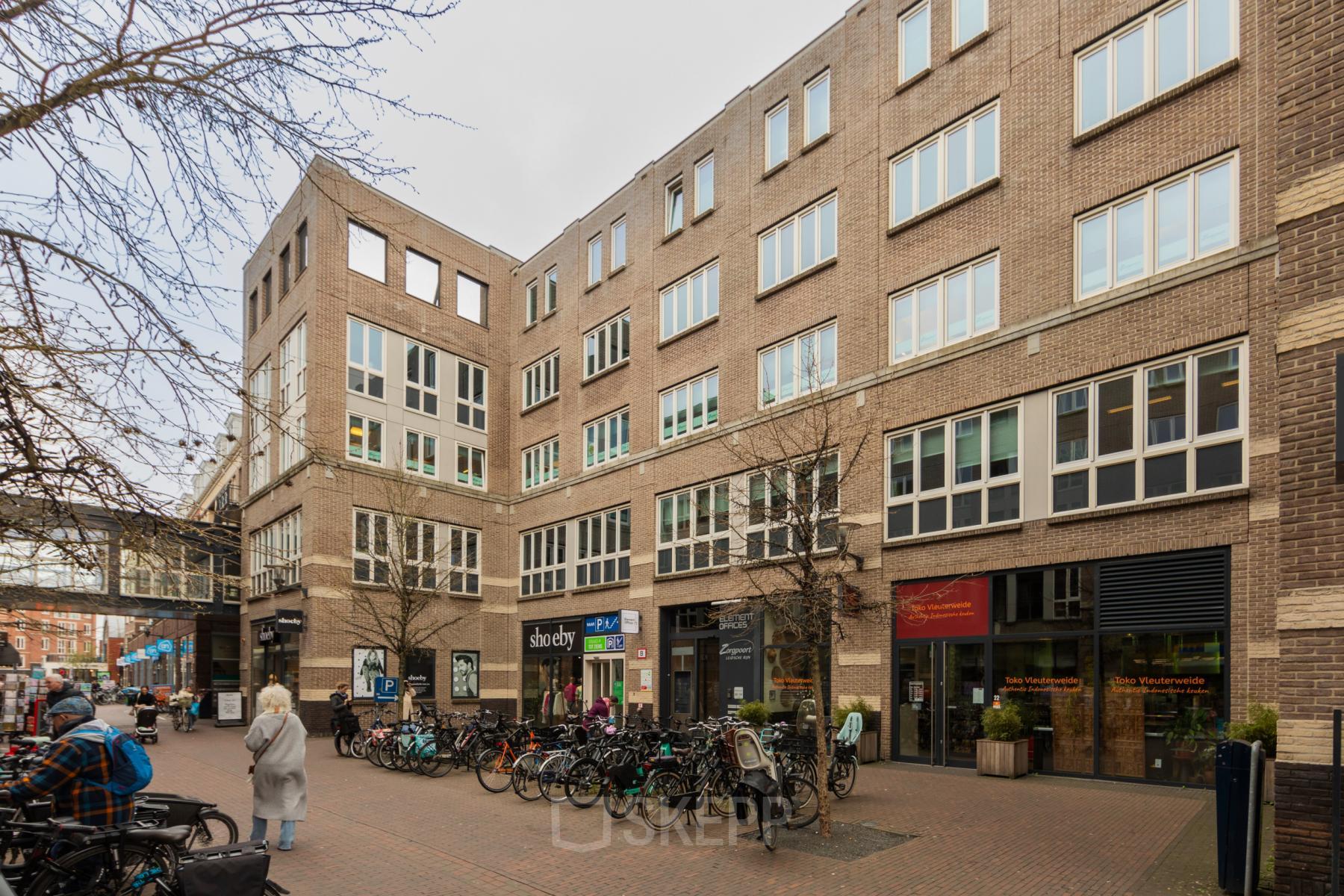 Bakstenen kantoorpand op Middenburcht 136 in Utrecht Leidsche Rijn met fietsenstalling en verschillende winkels op de begane grond. Ideale locatie voor kantoorruimte huren.