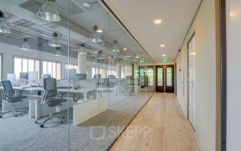 Moderne werkruimte met gestoffeerde bureaus en natuurlijk licht op Goeman Borgesiuslaan 77, ideaal voor bedrijven die een kantoor willen huren in Utrecht Noord.