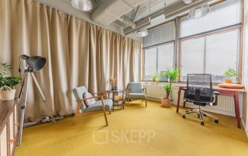 Lichte kantoorruimte huren met een grote raampartij, gele vloerbedekking en planten, gelegen op Goeman Borgesiuslaan 77 in Utrecht Noord.