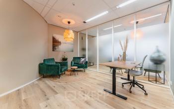 Stijlvolle kantoorruimte huren op Goeman Borgesiuslaan 77, Utrecht Noord. Lichte ruimte met houten vloer, moderne meubels en glazen scheidingswand, ideaal voor productieve werkuren.