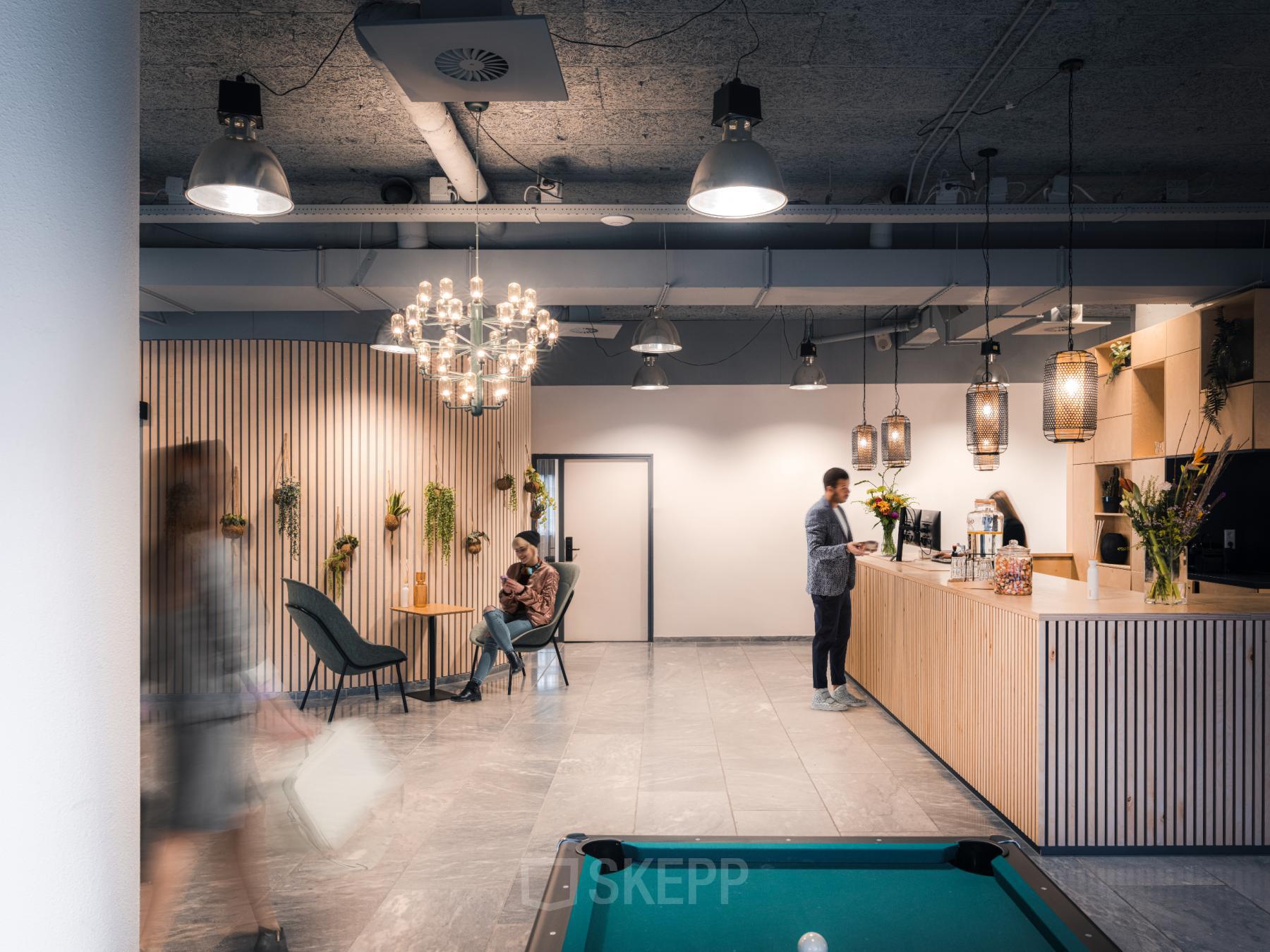Moderne lounge met comfortabele zitgelegenheid en pooltafel in een kantoorpand aan de Goeman Borgesiuslaan 77, Utrecht Noord.