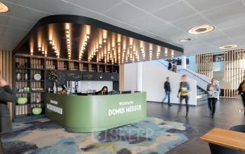 Foto van de receptieruimte in het kantoorpand op Mercatorlaan 1198-2000, Utrecht Papendorp. Zakenmensen lopen rond en een receptionist zit aan de balie.