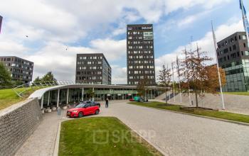 Buitenkant van kantoorpand op Papendorpseweg 95-97 in Utrecht Papendorp, met moderne architectuur en mensen die zakelijke gesprekken voeren. Ideale locatie voor kantoorruimte huren.