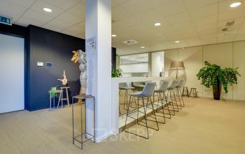 Moderne en lichte kantoorruimte in Utrecht Papendorp aan de Orteliuslaan 850, met hoge stoelen en een bar voor informele meetings.