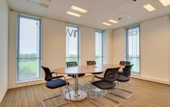 Moderne vergaderruimte in kantoorpand te Utrecht Papendorp, Orteliuslaan 850, met een ronde tafel en comfortabele stoelen, veel daglicht.
