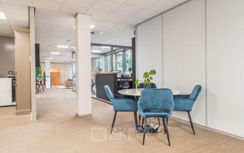 Kantoorruimte huren in Utrecht Papendorp met een open vloerplan. Het kantoorpand heeft een moderne inrichting met comfortabele blauwe stoelen rondom een tafel.